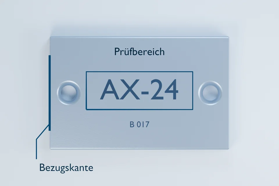 Draufsicht auf dasselbe Bauteil. Ein blauer Rahmen markiert den Prüfbereich um AX-24; eine separate Markierung hebt die linke Bezugskante hervor.