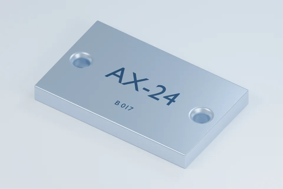 Räumliche Illustration eines Aluminiumbauteils mit zwei Befestigungsbohrungen und dem Aufdruck AX-24.